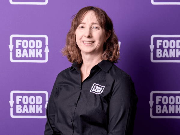 Moira Aynsley in front of Foodbank banner
